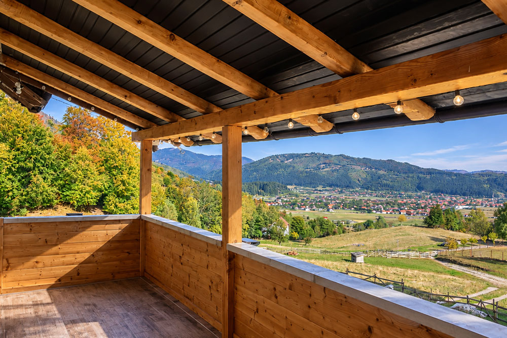 Balcon din lemn cu priveliste spre munte la Dolce Far Niente